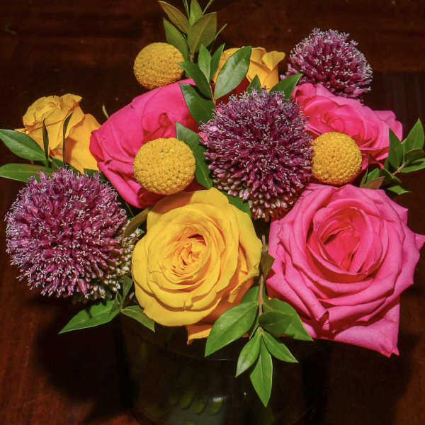 Bouquet of pink and yellow roses with purple allium blooms