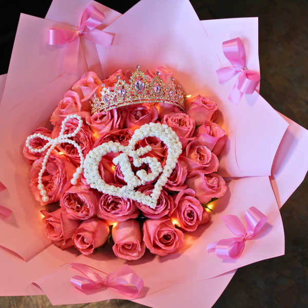 Pink rose bouquet with a jeweled crown and heart decorations