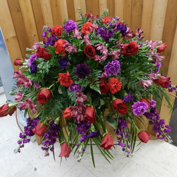 Large standing floral spray with red roses and purple flowers