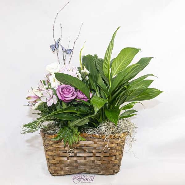 Pink roses and lilies in a wicker basket with greenery and butterfly picks