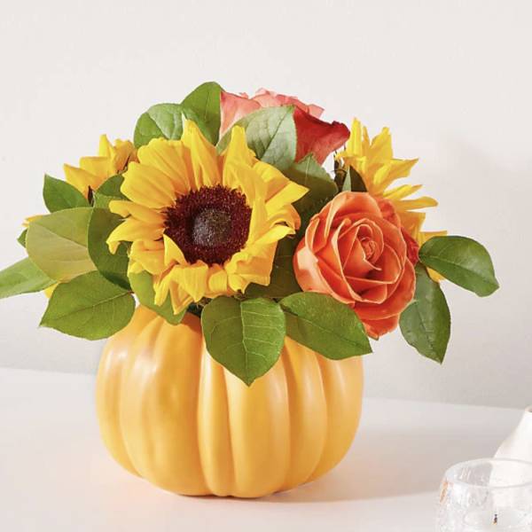 Sunflower and rose arrangement in a pumpkin-shaped vase