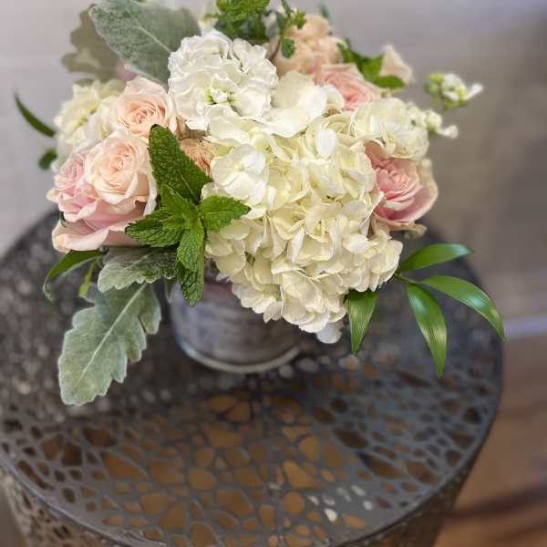 Bouquet of pale pink roses and white hydrangeas in a metal vase