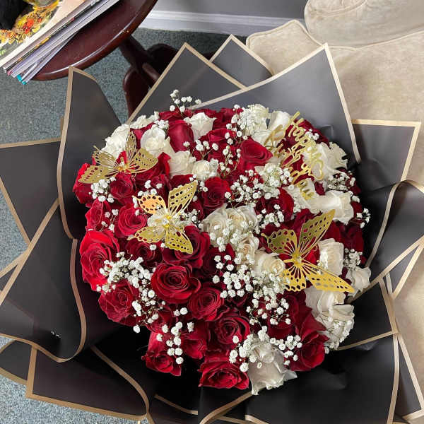 Bouquet of red and white roses with gold butterfly accents