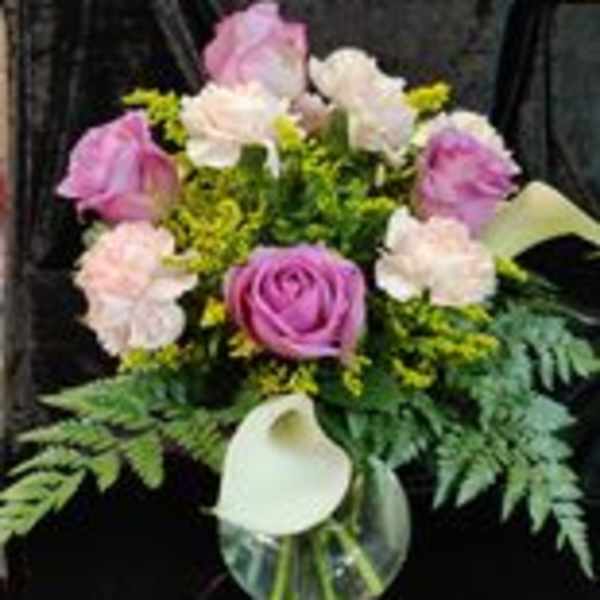 Pink and white bouquet with a white calla lily in a glass vase