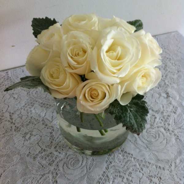 Cream rose bouquet in a clear glass vase