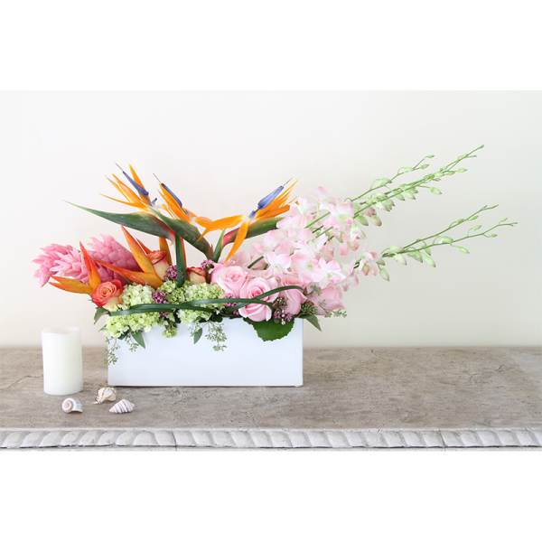 Tropical flower arrangement in a white rectangular box with pink roses