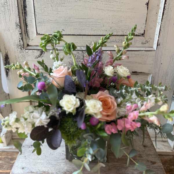 Mixed bouquet in a glass vase with pink, peach, and white flowers