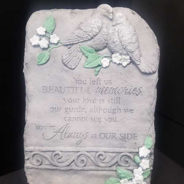 Stone memorial plaque with two doves and floral accents