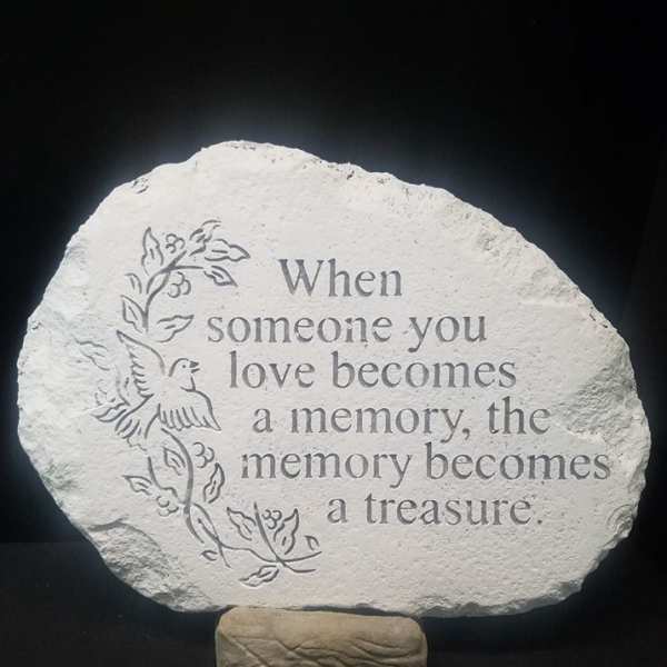 Memorial stone with engraved quote and dove design on a stand