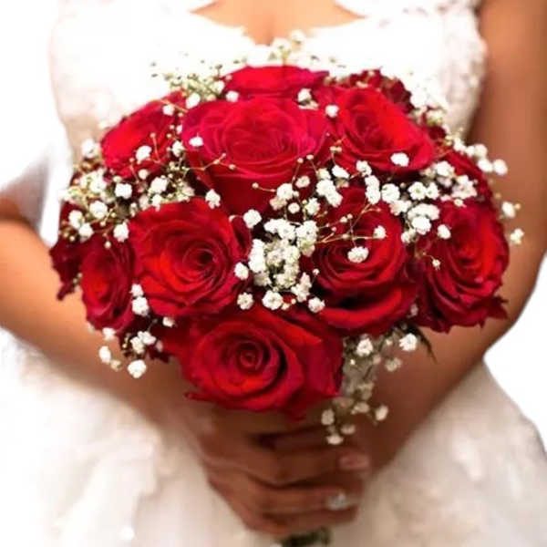 Bride holding a bouquet of red roses with baby's breath