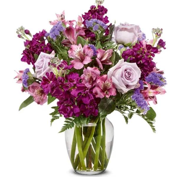Bouquet of pink and purple flowers in a clear glass vase
