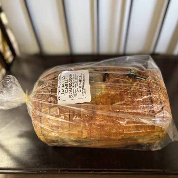 Wrapped loaf of jalapeño cheddar sourdough bread on a chair