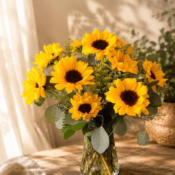 Bouquet of yellow sunflowers in a clear glass vase