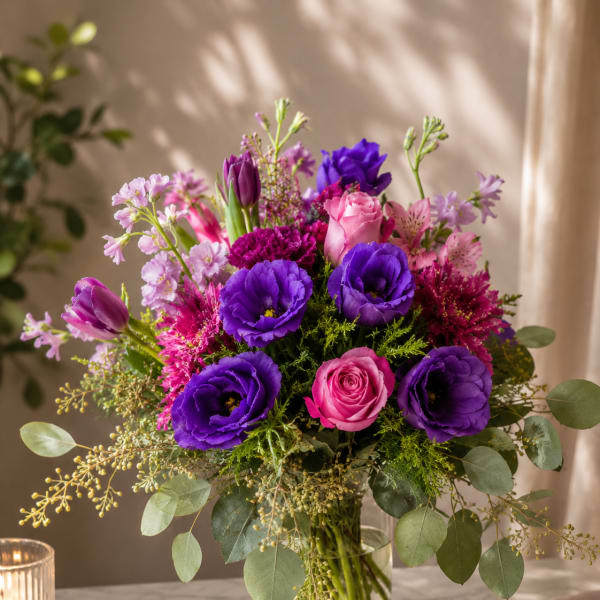 Purple and pink bouquet in a clear glass vase
