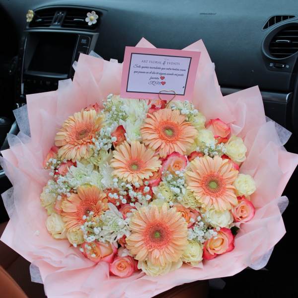 Pink bouquet with peach gerbera daisies and roses in a car seat