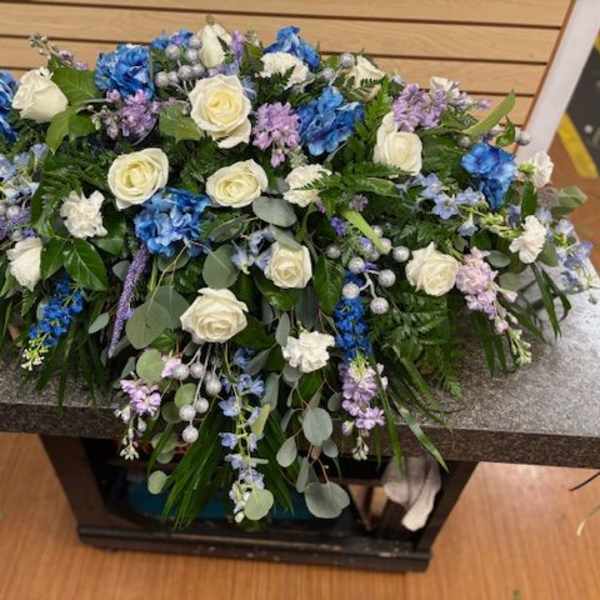 Large floral arrangement with white and blue roses on a stone table
