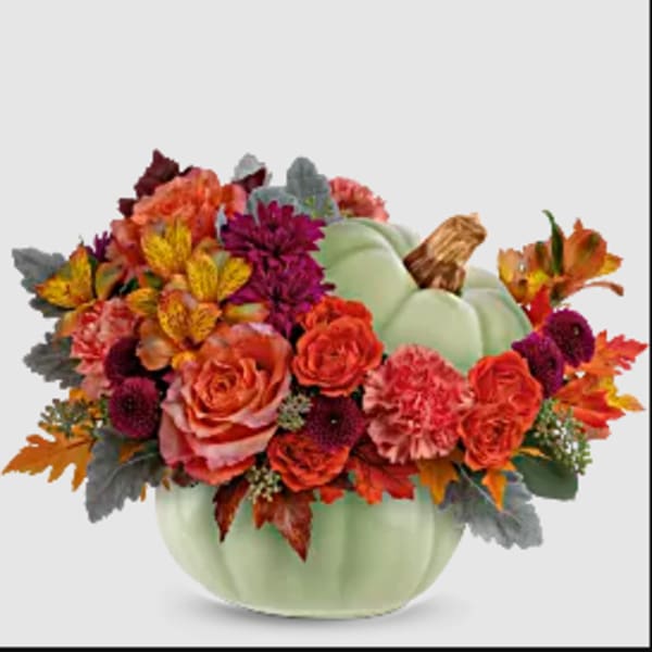 Fall floral arrangement in a pale green pumpkin container