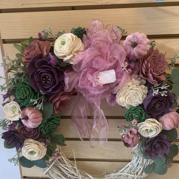 Heart-shaped floral wreath with pink ribbon and mixed blooms