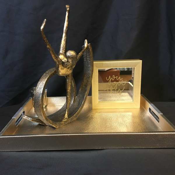 Gold decorative tray with abstract sculpture and framed mirror sign