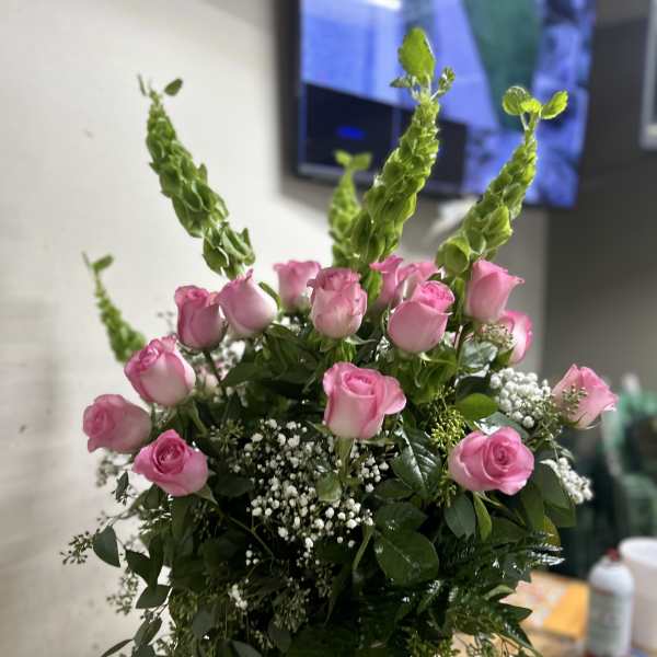 Pink roses with tall green spikes in a bouquet