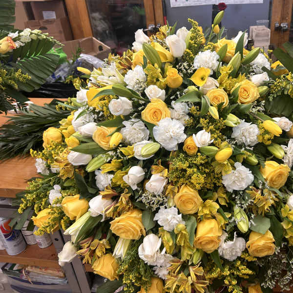 Large yellow and white floral spray with roses, lilies, and carnations