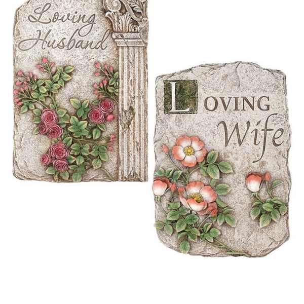 Two decorative memorial stones with floral relief and engraved names