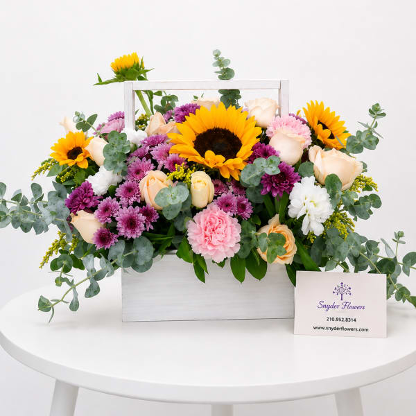 Mixed bouquet in a white wooden box with sunflowers, roses, and purple blooms