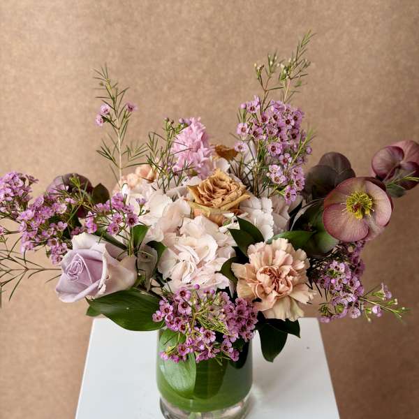 Mixed bouquet of pink and cream flowers in a glass vase