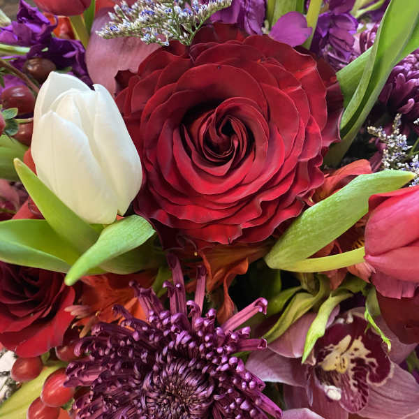 Mixed bouquet with red and white tulips, a red rose, and purple flowers