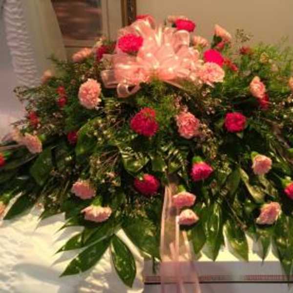 Large pink and red floral spray with ribbon accents