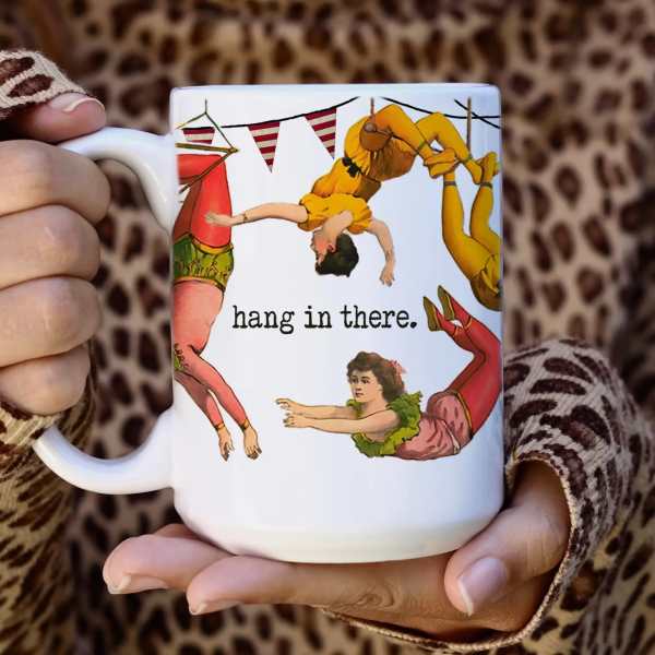 White mug with illustrated dancers and the words "hang in there."