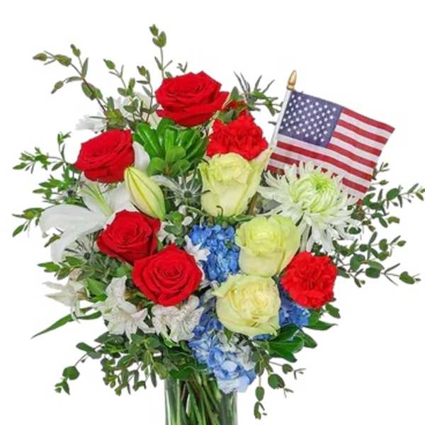 Red and white rose bouquet in a glass vase with an American flag