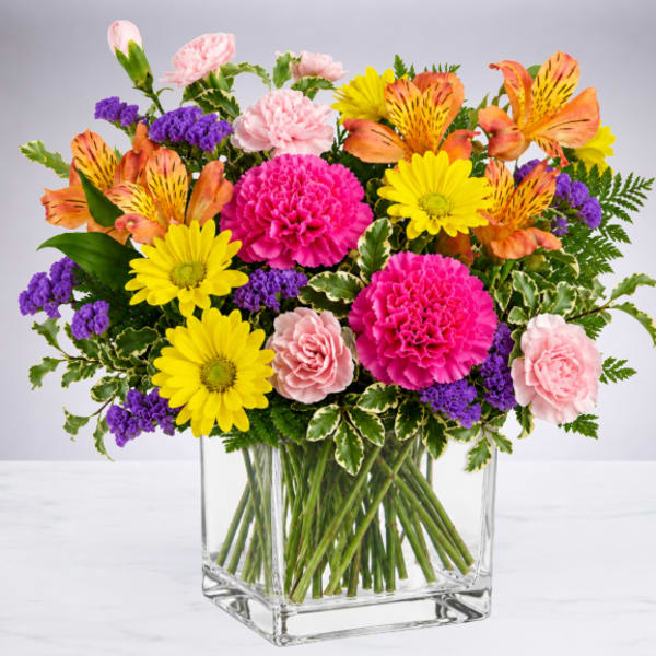 Colorful mixed bouquet in a clear square glass vase
