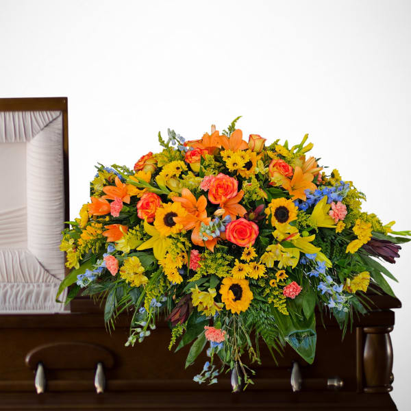 Bright mixed flower spray on a casket