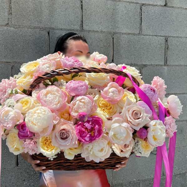 Large basket of pink and cream roses held by a person