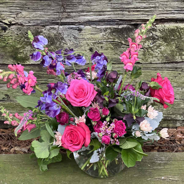 Pink and purple mixed flower arrangement in a glass vase