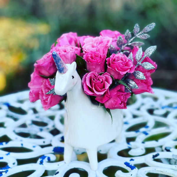 Pink rose bouquet in a white unicorn vase