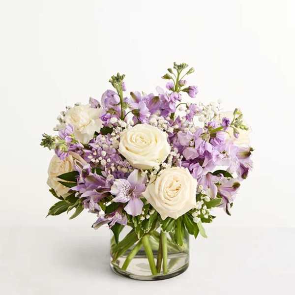 Lavender and white flower arrangement in a clear glass vase