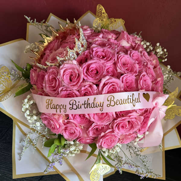 Pink rose bouquet with a birthday ribbon and butterfly decorations