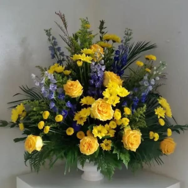 Yellow roses and purple flowers in a white vase