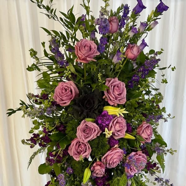 Tall standing floral spray with pink roses and purple blooms