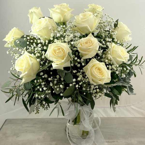Bouquet of white roses and baby's breath in a glass vase