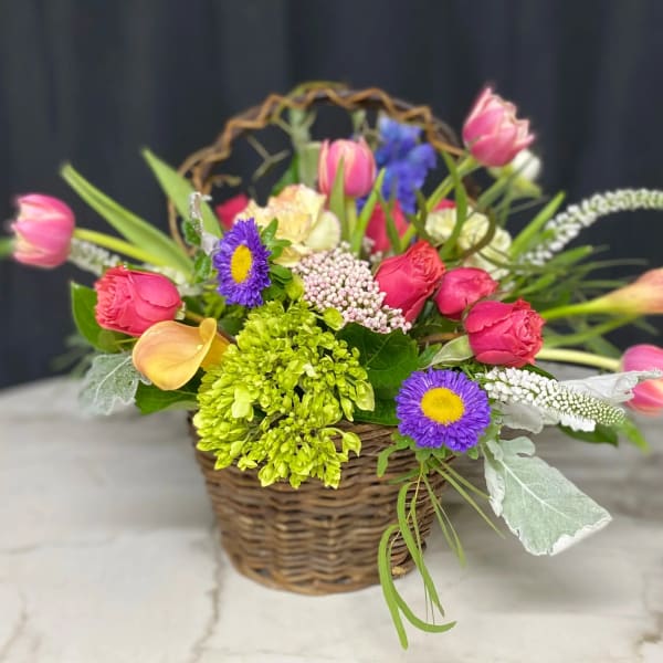 Colorful mixed flower arrangement in a wicker basket
