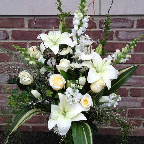 White lilies and cream roses in a tall arrangement