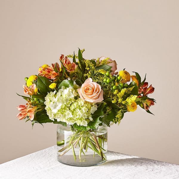Mixed bouquet of peach roses and white hydrangeas in a glass vase