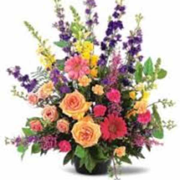 Mixed bouquet with roses and tall purple flowers in a vase