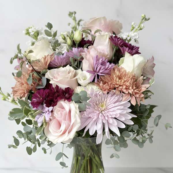 Pastel mixed flower bouquet in a clear glass vase