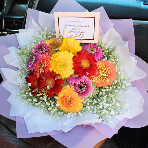 Colorful bouquet of gerbera daisies wrapped in lavender paper