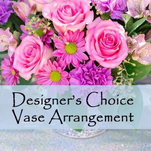 Pink roses and purple daisies in a vase arrangement