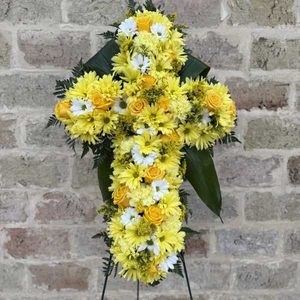Yellow and white floral cross on a stand